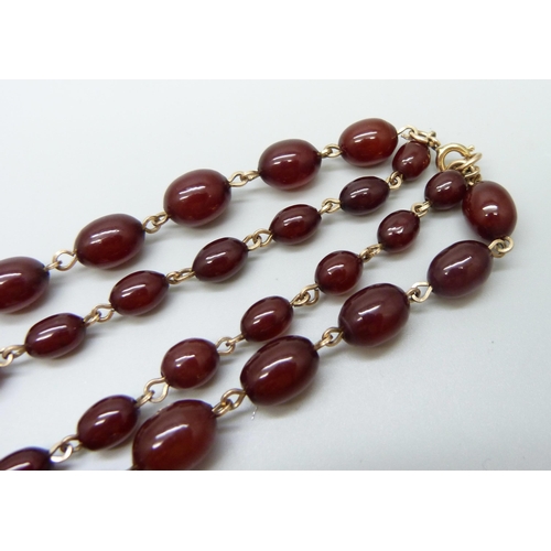 7146 - A two row sherry amber necklace, 54g, largest bead 2.2 x 1.6cm