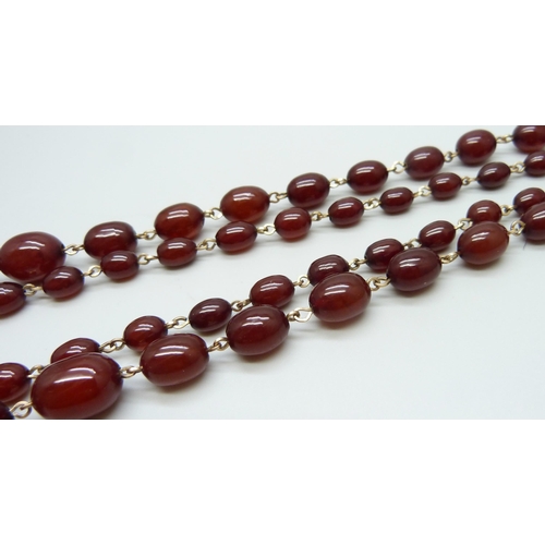 7146 - A two row sherry amber necklace, 54g, largest bead 2.2 x 1.6cm