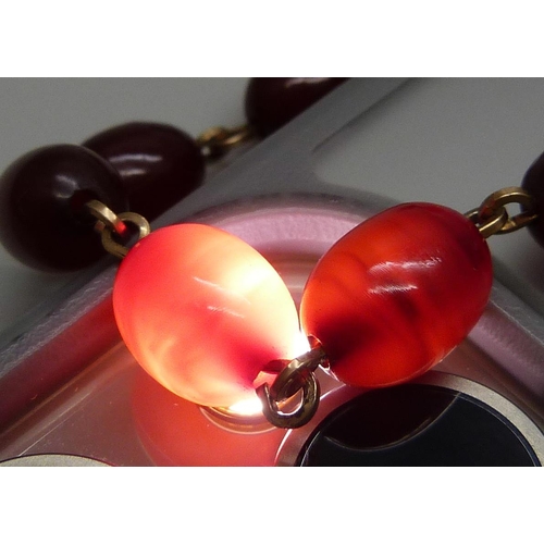 7146 - A two row sherry amber necklace, 54g, largest bead 2.2 x 1.6cm