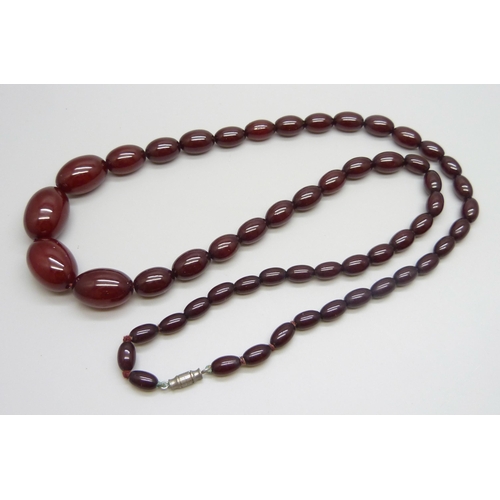 7148 - A sherry amber necklace, 51g, largest bead 2.4 x 1.7cm