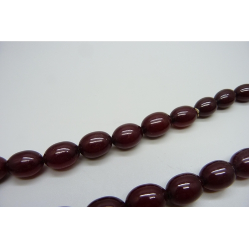 7149 - A sherry amber necklace with a 9ct gold clasp, 66g, requires re-stringing, largest bead 2.8 x 2cm