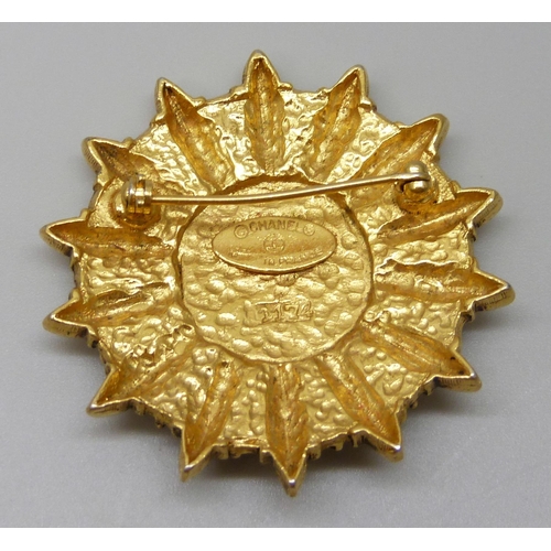 7150 - A Chanel gold tone CC logo sun shield brooch marked Chanel, made in France, 4.3cm