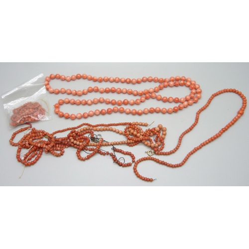 7155 - A long string of coral beads, 64g, together with loose coral beads and necklaces for repair, one wit... 