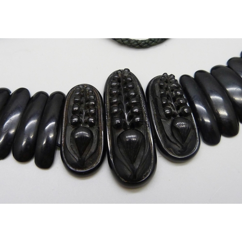 7157 - A circa 1900 Art Nouveau carved Whitby jet collar panel necklace, 56g, together with a pendant, 20g