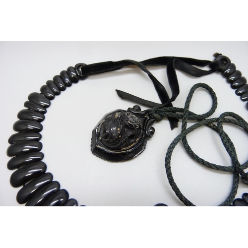 7157 - A circa 1900 Art Nouveau carved Whitby jet collar panel necklace, 56g, together with a pendant, 20g