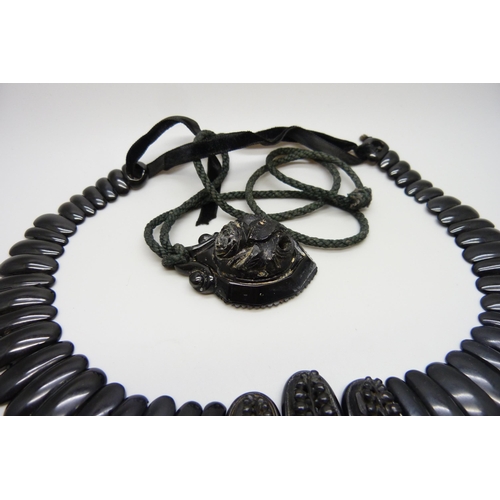 7157 - A circa 1900 Art Nouveau carved Whitby jet collar panel necklace, 56g, together with a pendant, 20g