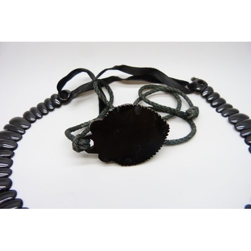 7157 - A circa 1900 Art Nouveau carved Whitby jet collar panel necklace, 56g, together with a pendant, 20g