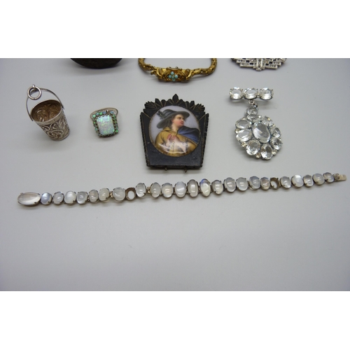 7160 - A white metal and moonstone bracelet (two stones missing) a silver and synthetic opal ring (lacking ... 