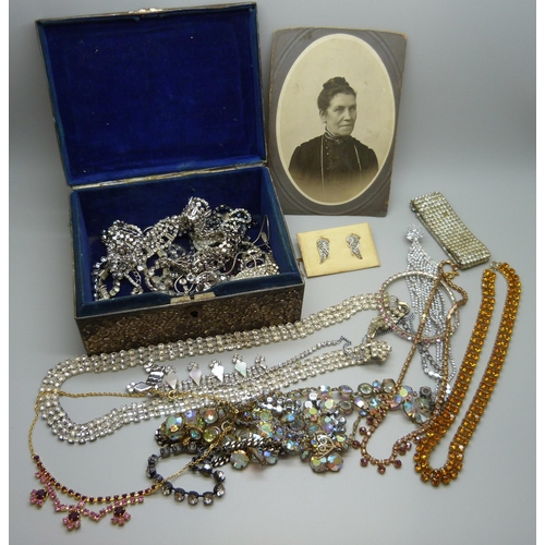 7168 - A collection of paste set costume jewellery in a plated Oriental box with dragon decoration