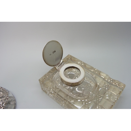 7236 - Two silver topped inkwells, ornate example Birmingham 1903, glass a/f on the other, 10.1 x 7.3cm