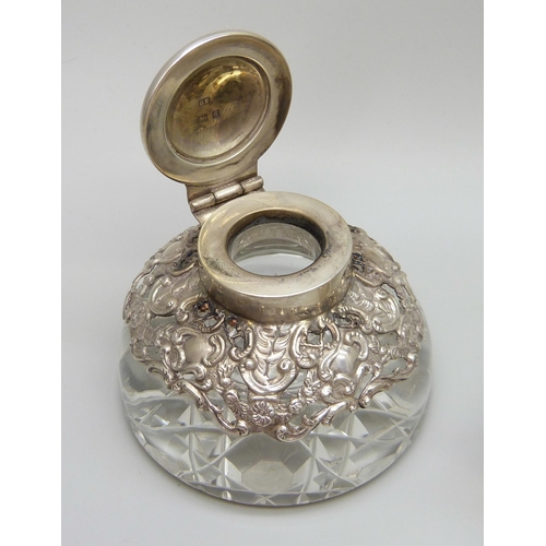 7236 - Two silver topped inkwells, ornate example Birmingham 1903, glass a/f on the other, 10.1 x 7.3cm