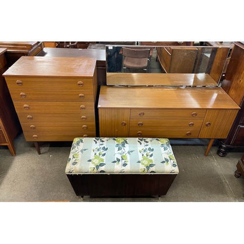 71 - A Schreiber teak dressing table, chest of drawers and an ottoman