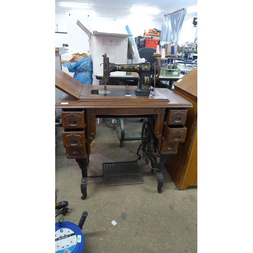 5096 - A vintage sewing machine mounted on a vintage cast iron based sewing machine table