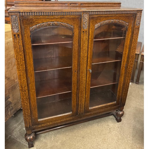 164 - An early 20th Century carved oak two door bookcase