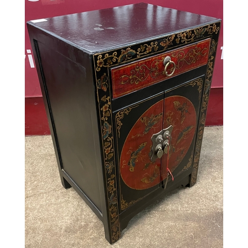 117A - An oriental style black and red lacquered chinoiserie side cabinet