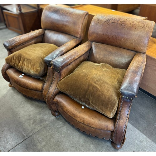 185 - A pair of early 20th Century tan leather armchairs