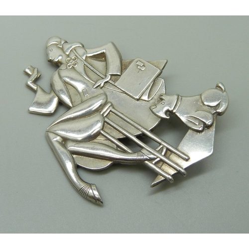 1005 - An Art Deco style brooch depicting a lady and dog, 6cm