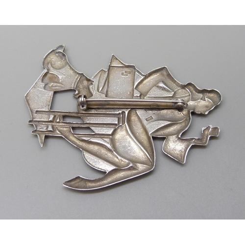 1005 - An Art Deco style brooch depicting a lady and dog, 6cm