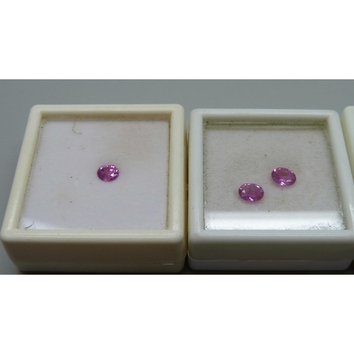 1009 - A set of boxed stones comprising a pink sapphire and two matched pink oval cut sapphires and a large... 