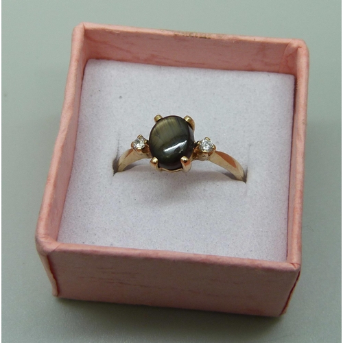 1044 - A 14ct gold ring set with a cat's eye and diamonds, 2.3g, O