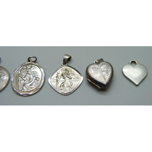 1055 - A collection of silver including two St Christopher pendants, two lockets and a ring, together with ... 