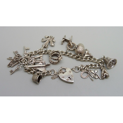 1061A - A silver charm bracelet with silver and white metal charms, 39g