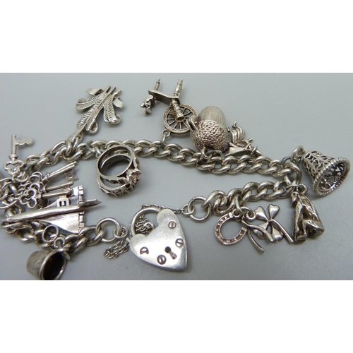 1061A - A silver charm bracelet with silver and white metal charms, 39g