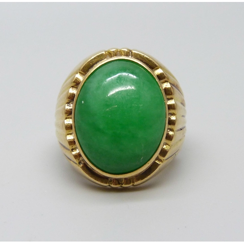 1088 - A yellow metal ring set with a cabochon jade stone, 12.5g, M