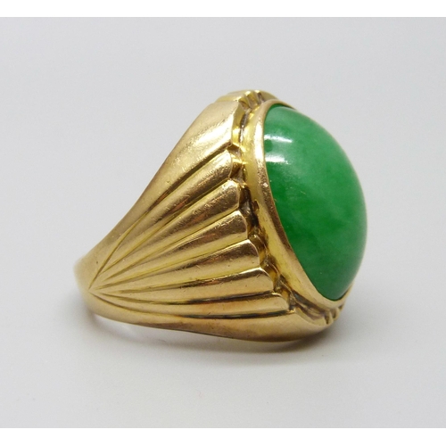 1088 - A yellow metal ring set with a cabochon jade stone, 12.5g, M