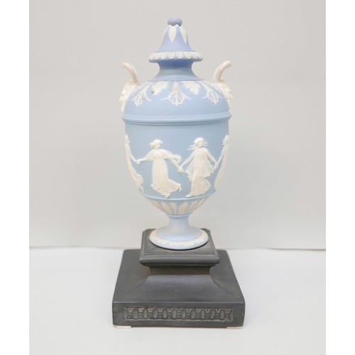 610 - A Wedgwood blue jasper twin handled urn and cover on a square black basalt stand, 19.5cm