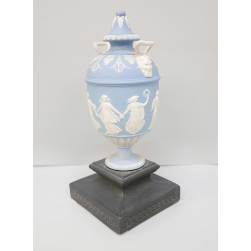 610 - A Wedgwood blue jasper twin handled urn and cover on a square black basalt stand, 19.5cm