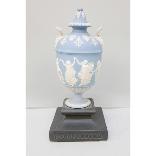 610 - A Wedgwood blue jasper twin handled urn and cover on a square black basalt stand, 19.5cm