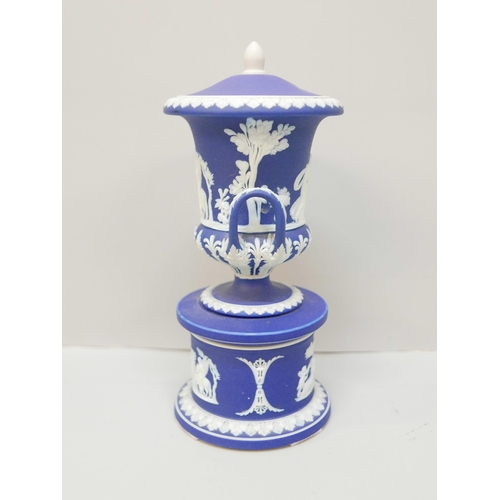 614 - A Wedgwood dark blue jasper twin handled urn with cover on a circular stand, 19cm