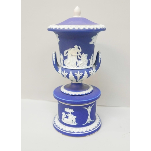 614 - A Wedgwood dark blue jasper twin handled urn with cover on a circular stand, 19cm