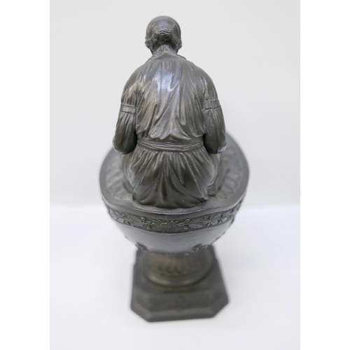 616 - A Wedgwood black basalt vestal oil lamp and cover, the female figure reading a book seated upon the ... 