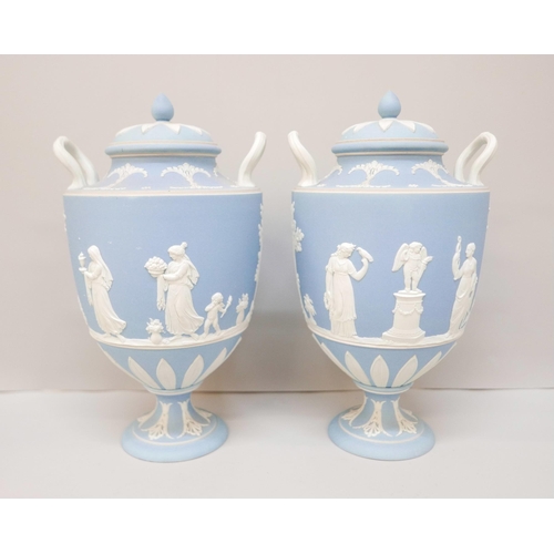 617 - A pair of Wedgwood blue jasper twin handled urns with covers, 24.5cm