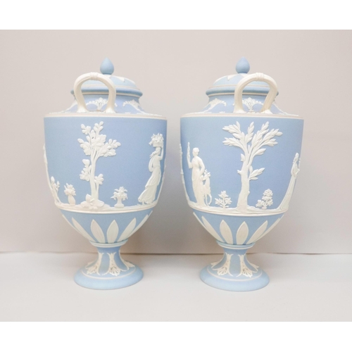 617 - A pair of Wedgwood blue jasper twin handled urns with covers, 24.5cm