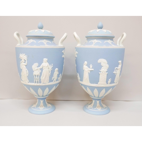 617 - A pair of Wedgwood blue jasper twin handled urns with covers, 24.5cm