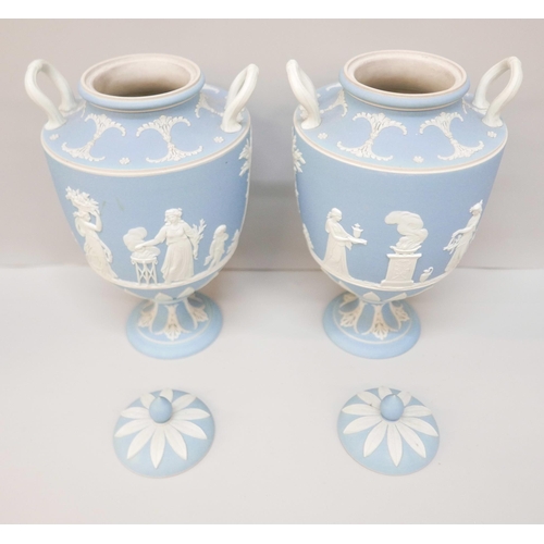 617 - A pair of Wedgwood blue jasper twin handled urns with covers, 24.5cm