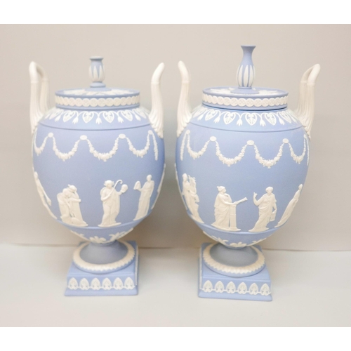 620 - A pair of Wedgwood blue jasper twin handled urns and covers (finals on covers not identical), 31cm, ... 