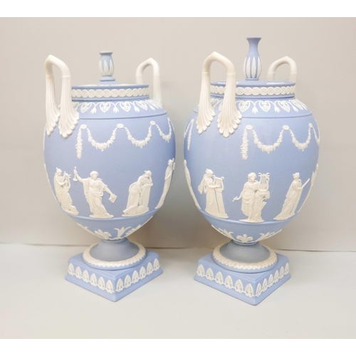 620 - A pair of Wedgwood blue jasper twin handled urns and covers (finals on covers not identical), 31cm, ... 