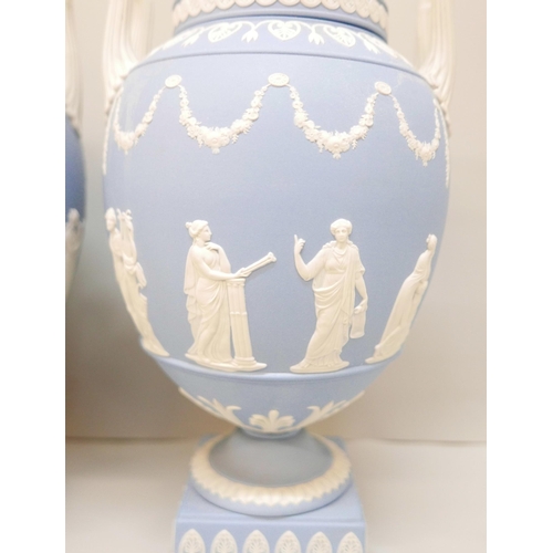 620 - A pair of Wedgwood blue jasper twin handled urns and covers (finals on covers not identical), 31cm, ... 