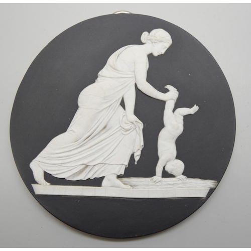 626 - A pair of Wedgwood black and white circular plaques and an oval plaque, each with classical scenes