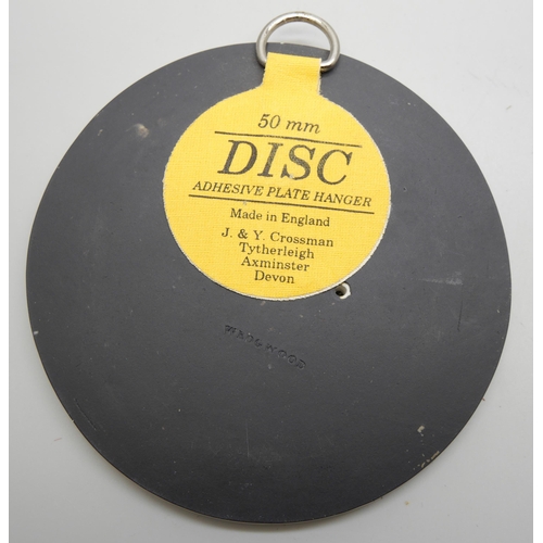 626 - A pair of Wedgwood black and white circular plaques and an oval plaque, each with classical scenes