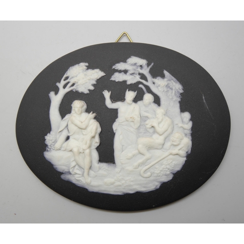 626 - A pair of Wedgwood black and white circular plaques and an oval plaque, each with classical scenes