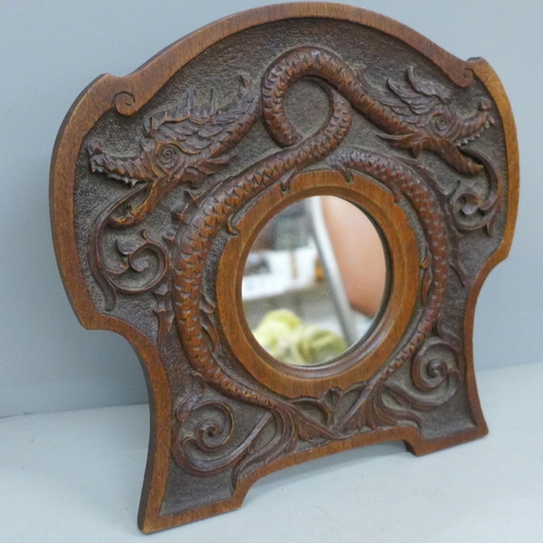 756 - An Arts and Crafts carved oak framed mirror, the carving depicts two interlocking serpents, c.1900, ... 