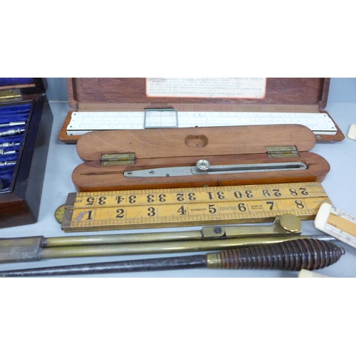 788 - A collection of drawing instruments and rulers including a boxed set