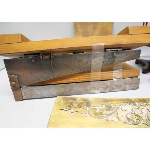 821 - A collection of printing plates, two leather measuring tapes including one dated 1915, a wooden pape... 