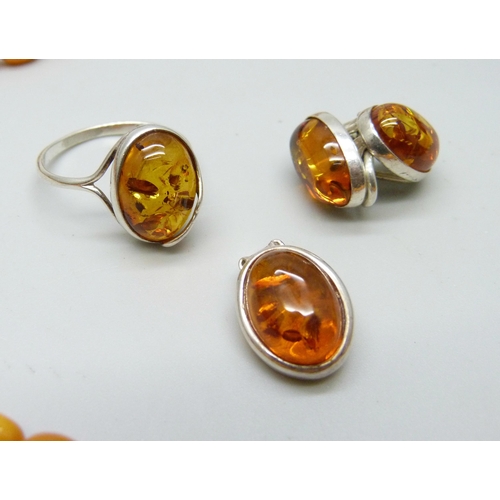 957 - A collection of amber and amber style jewellery including a silver mounted ring