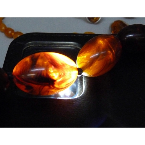 957 - A collection of amber and amber style jewellery including a silver mounted ring